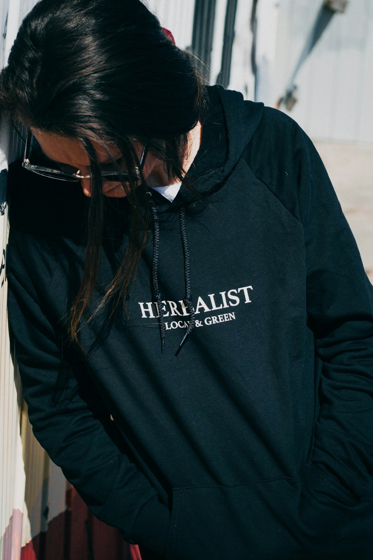 A person wearing a dark hoodie with a printed design