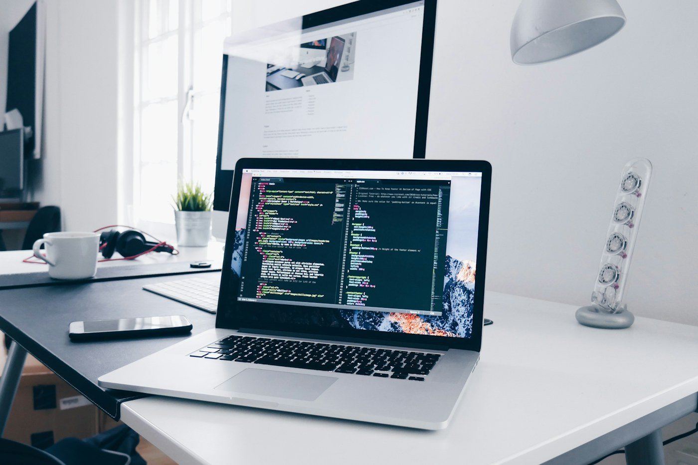 A laptop screen displaying code on a desk